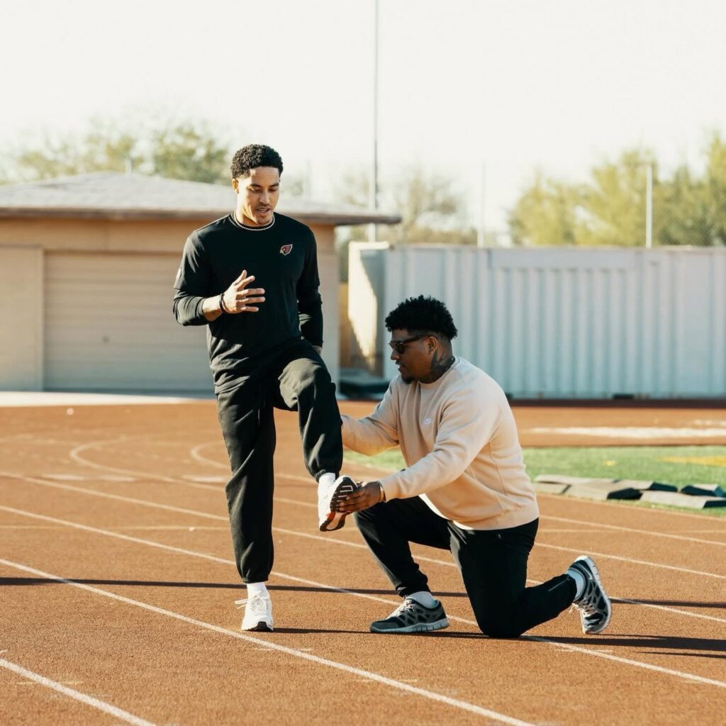 Stealth coach working on sprint mechanics with an NFL athlete on the track