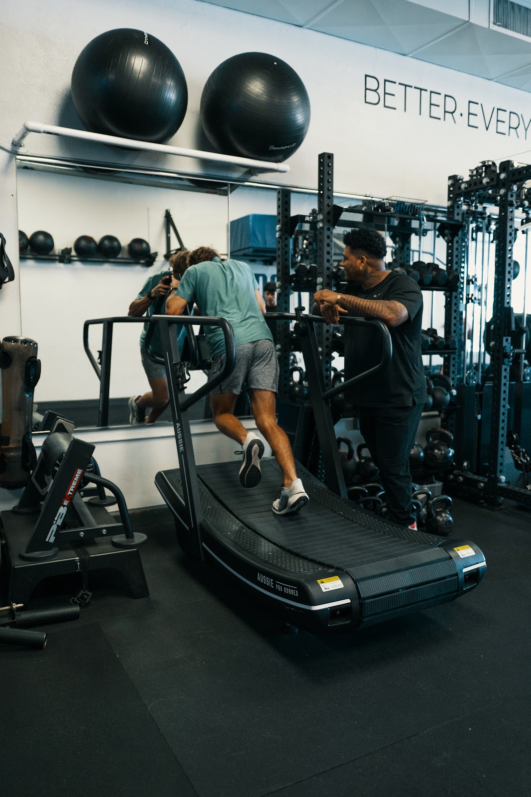 Stealth coach cueing a client on a curved treadmill sprint in semi-private training