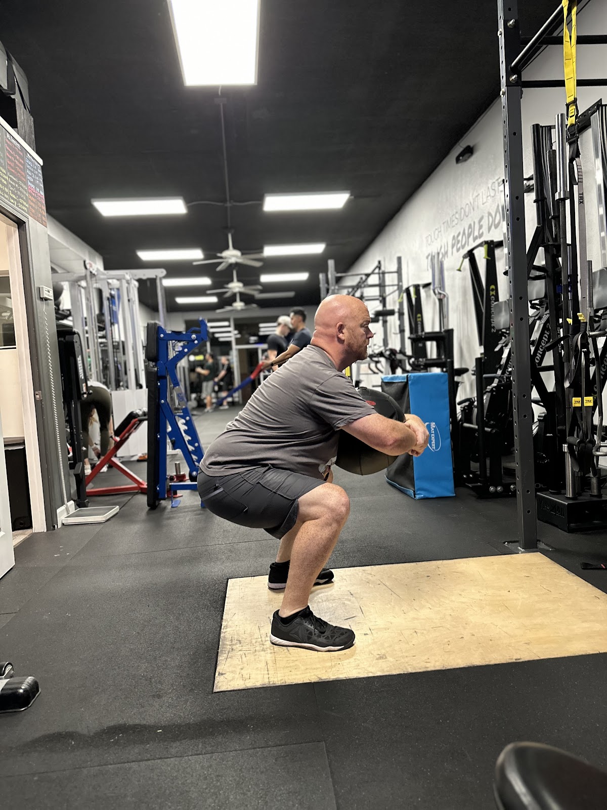 Adult client doing a goblet squat on his own program in semi-private training in Arcadia, Phoenix