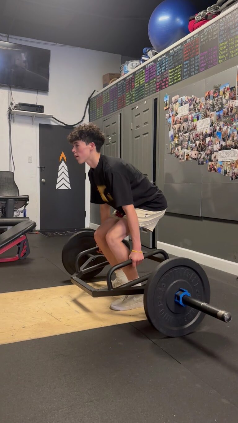 High school athlete pushing a weighted sled in youth strength training at Stealth Performance