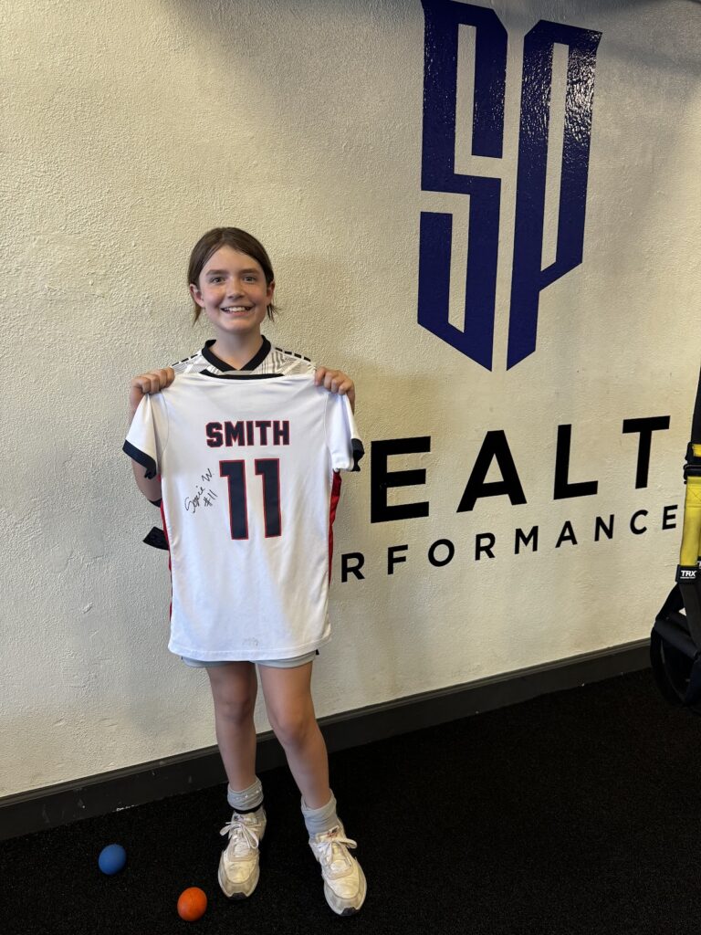 Young athlete holding a signed jersey at Stealth Performance in Phoenix